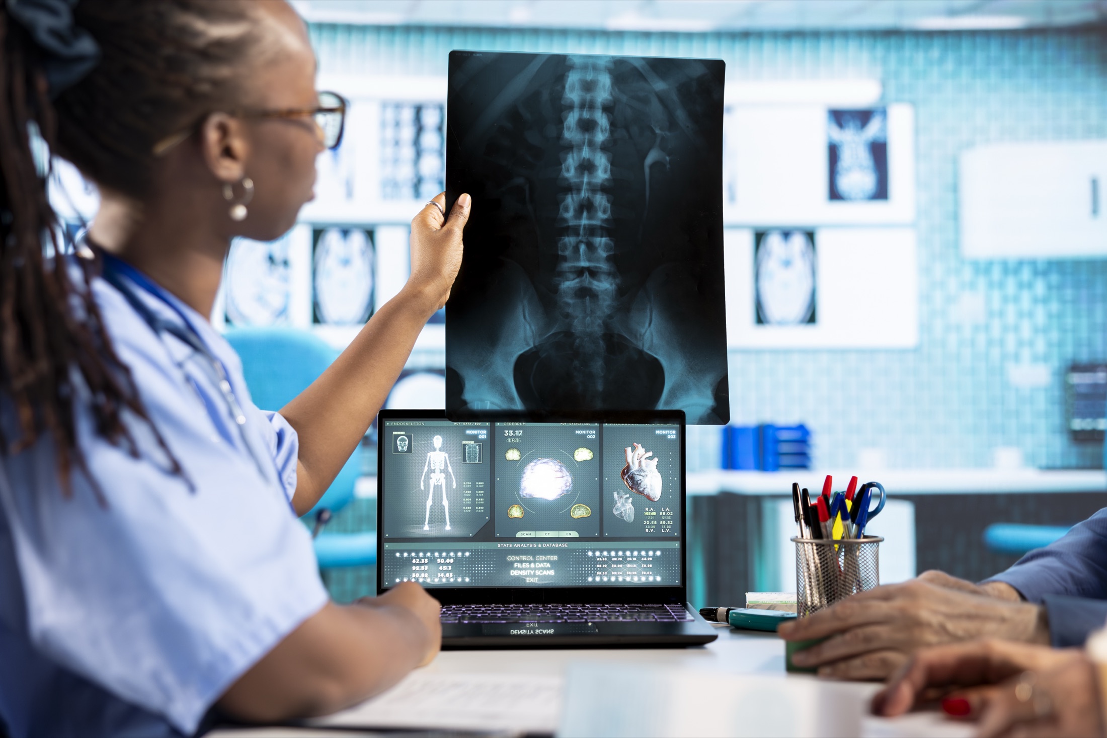 Médico revisando una imagen médica junto a una estación de trabajo de diagnóstico